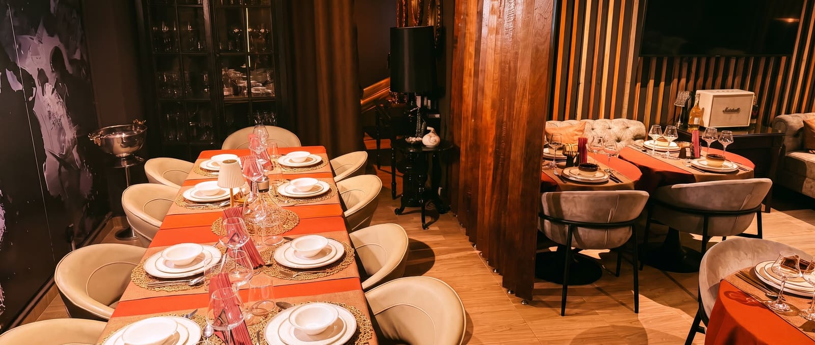 Sala do Parampas ao anoitecer, com sofás chesterfield e mesas de linho terracota